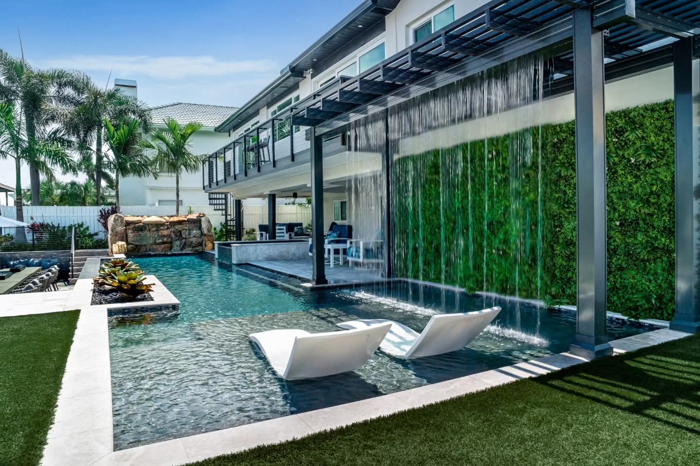 Custom pool with water feature and outdoor living area
